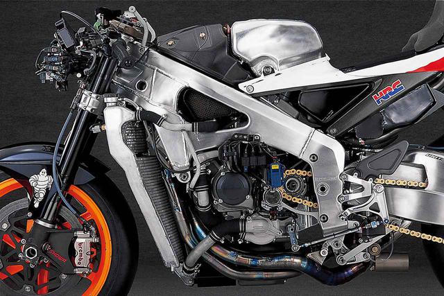 画像: “HONDA”の文字のある円形のカバー/金色のクラッチレリーズシリンダー/ドライブスプロケットの3つの位置関係を見比べると、こちらのほうがクランクシャフト〜ミッション間の距離が長いことがわかる。2車の比較では“ニュージェネレーション”の激変ぶりに目を奪われがちであるが、こちらのほうも開発は継続されており、コーナー進入時のホッピング対策として、従来は横への振れを抑える方向で開発していたが、2005年モデルで一定の成果を得た後は、縦方向への振れを抑えるのを重要なテーマとして改善を進めた。