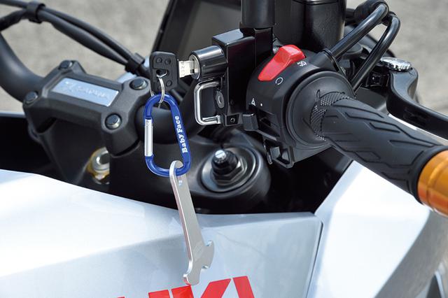 画像: 「ヘルメットロック ミラーホルダータイプ 32㎜」(7000円+税)はフロントマスター部またはクラッチ側に装着するアイテム。カラビナとその下のパーツはヘルメットのDリングに挿入しホルダーに付けやすくするアンカー(1500円+税)だ。