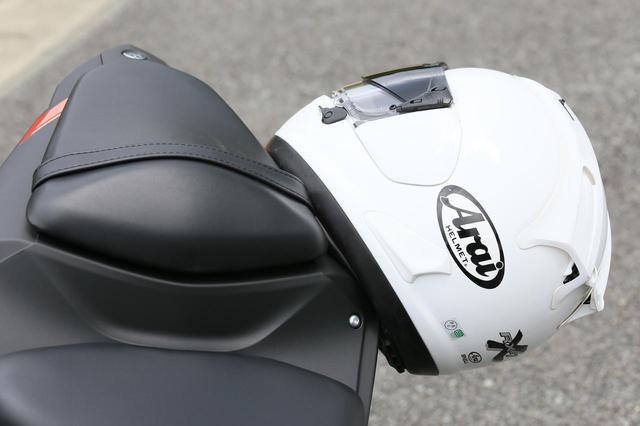画像: ヘルメットホルダーはリアシートのフックを使うタイプ。両側に掛けることが可能。
