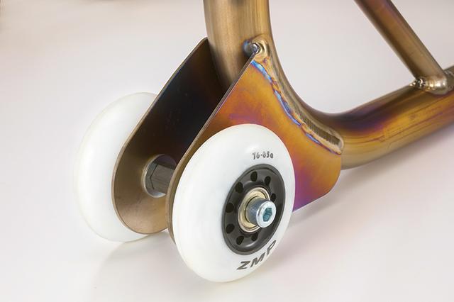 画像: 本体側の車輪受け部は高剛性なチタン材使用ならではの薄肉仕様。レース現場ではパドック内で持ち歩く機会の多いレーシングスタンドだから、その群を抜く軽量性はメカニックやスタッフの疲労軽減にも大いに役立つ。