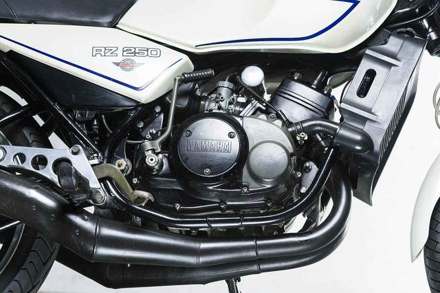 画像: 水冷ピストンリードバルブのパラツインエンジン。キャブレターはミクニVM26。パワーはRD250 より5PS 高めた35PS で、車両重量は11kg も軽量となった。レーサーのような多段断面のチャンバーも話題だった。