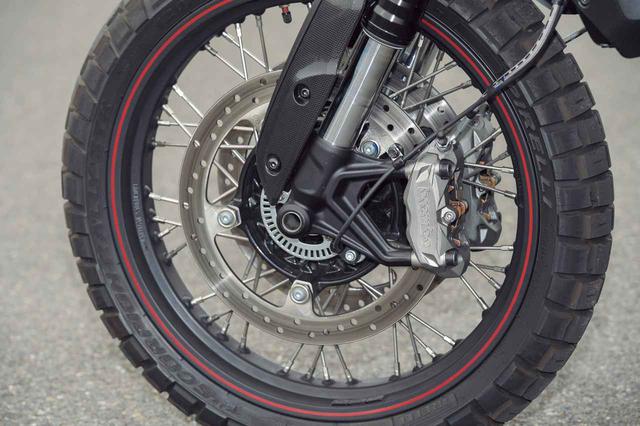 画像: ホイールのサイズ自体はFTR1200と同じフロント19・リア17インチだが、キャストホイールから軽量なアルミ製リムを使用したスポークホイールへと変更。タイヤはオフロード向けなブロックパターンのピレリ・スコーピオン・ラリーSTRが標準装着されている。強力な制動力を発揮する倒立フォークとブレンボ製のラジアルマウントキャリパーに関しては、FTR1200から基本的に変わっていない。