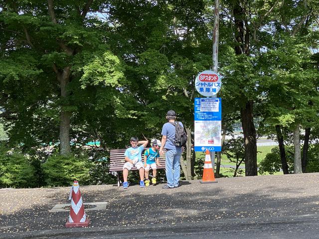 画像: バス停の横にはベンチがあり座りながら親子がバスを待っていました。