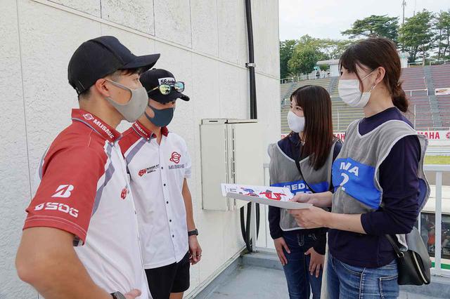 画像: 奥が名越選手。左手前の水野選手からのご連絡もお待ちしています! 実は、全日本ロードレースの開幕戦終了後、パドックでオートバイ女子部の大関さおりと梅本まどかがペーパークラフトのお願いをさせて頂きました。