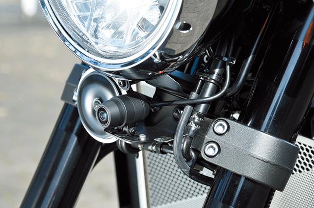 画像: 「Z900RS専用ドライブレコーダーステーセット」は新作で、ミツバ製EDR-21Gのフロント用カメラをこのようにヘッドライト下にマウントできる(本体やリヤ用ステーもセット)。リヤ用のドライブレコーダー用ナンバーステーやフロントブレーキ/クラッチ部にGPSアンテナやEDR-21G用スイッチボックスやGPSアンテナをマウントできる「ドライブレコーダー用スイッチステー」も、それぞれ単品でラインナップしている。