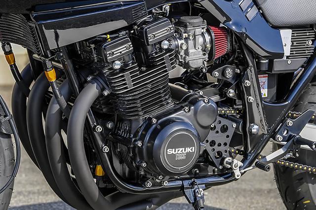 画像: エンジンは同店によるGSX1100Sの定番仕様(パワーも十分でライフも長い)となる1135ccで、スプロケットカバーはヨシムラ製。シフトシャフトをベアリング支持し、確実なシフトと良好なフィールを得るもの。イグニッションキーシリンダーはキャブレター下に移設された。