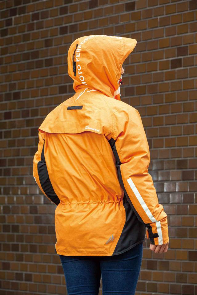 画像: フードは雨天時に役立つバイザー付き。背中上側にあるループに留められるので走行時のバタつきも防げる。
