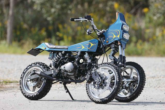 画像: ステアリングヘッドから後ろ側はカワサキZ125の車体をほぼそのまま使っているが、ステアリング機構は平行アームを採用した独自のタイプで、『ノスリス』と名付けられた電動/電動アシストビークルによく似ている。しかもステアリング周りのロッドやハブ、ホイールなどの主要パーツはアルミ削り出しで作られていて、仕上がりはワークスクオリティ。公式なアナウンスはなく、謎に包まれているが、「メーカーの開発実験車」と言われれば納得できる存在だ。