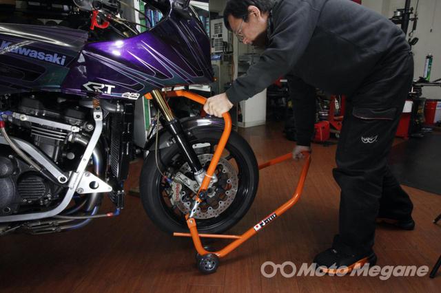 画像: 車体への干渉に注意してスタンドに体重をかけていけば、車体が浮き上がっていく。