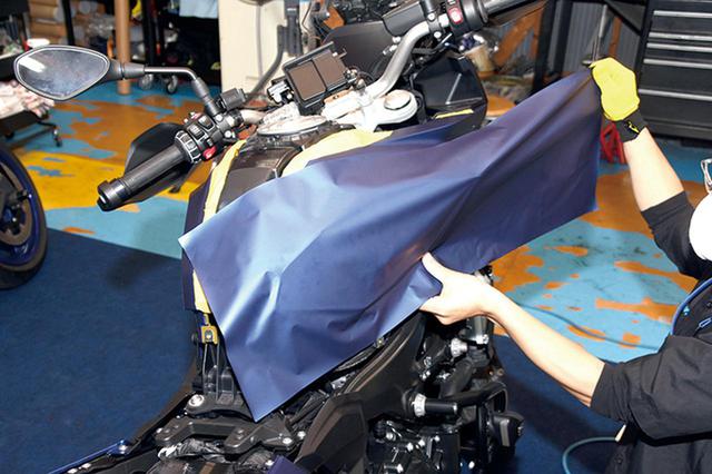 画像: 専用のヘラでエアを抜きながら圧着していく。