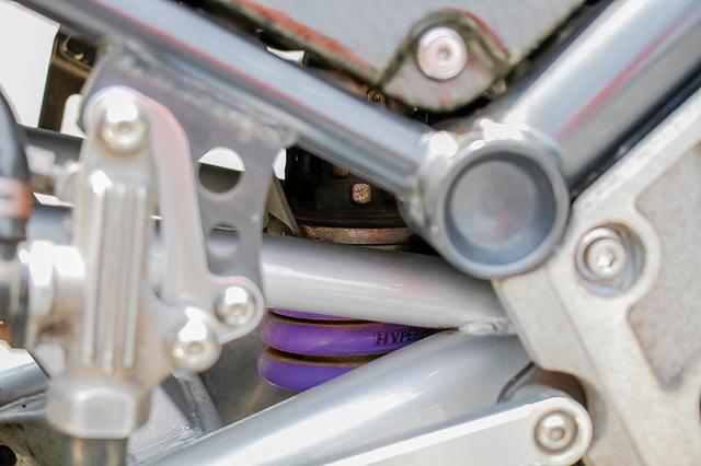 画像: 車体奥に見えるパープルのリヤスプリングはハイパープロ。リヤサスのリンクプレートも変更して車高をアップしている。リヤショック自体はペンタグラムで加工し、前後ともダンパーが効く特性に。