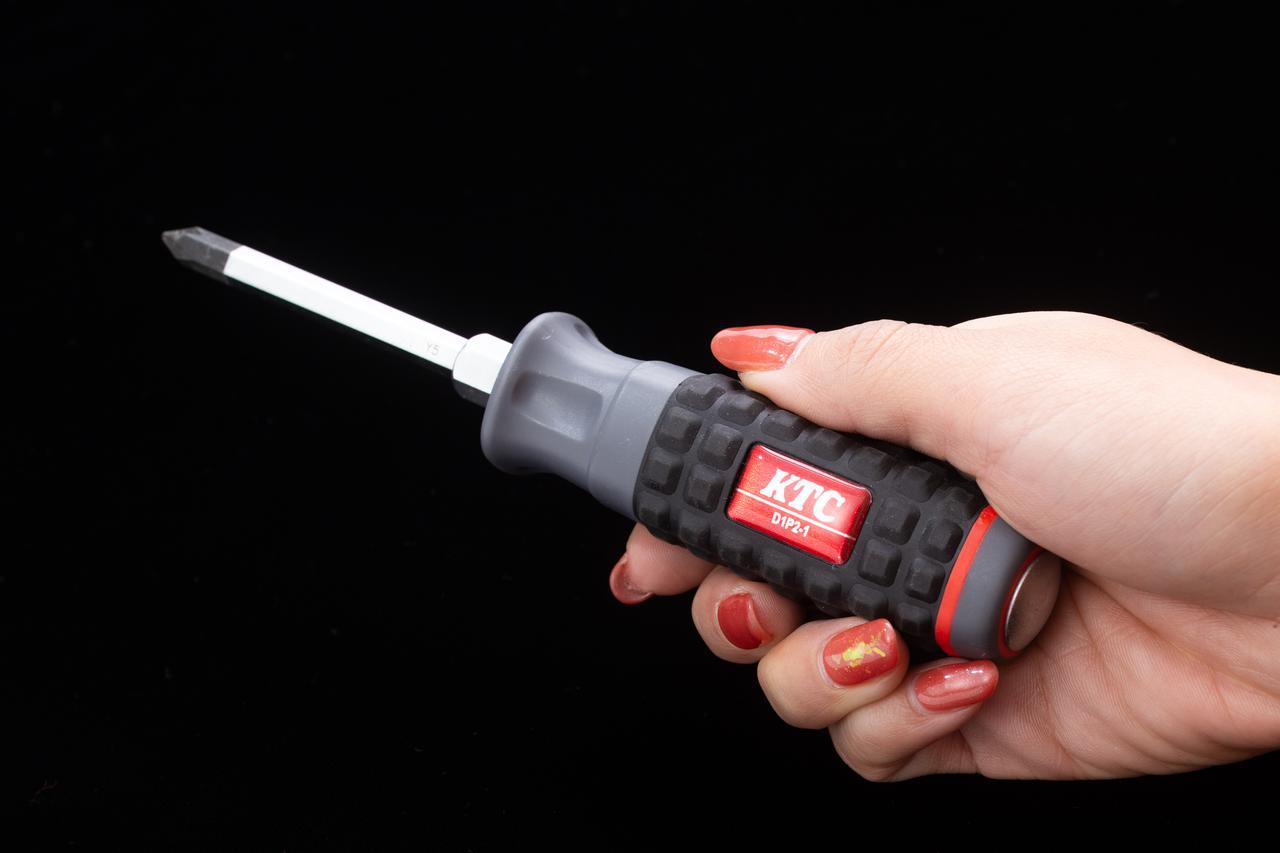 画像: ドライバーは力を入れやすい太めの樹脂柄を採用。貫通タイプなので頭のプラス溝が崩れていたり、硬く締まったネジをハンマーで叩きながら緩めることができる。 sk.ktc.jp