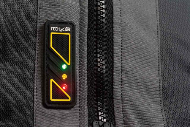画像: 前合わせジッパー横のLEDディスプレイでエアバッグの状態とバッテリー残量を確認できる。フル充電での駆動時間は約30時間。