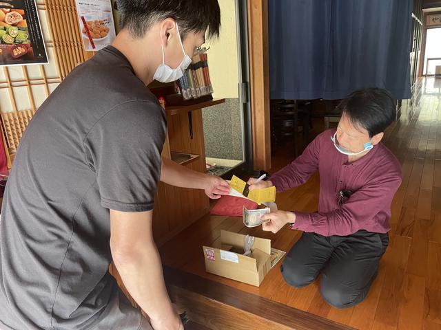 画像: 目的地近くの民宿で遊漁券購入の図。