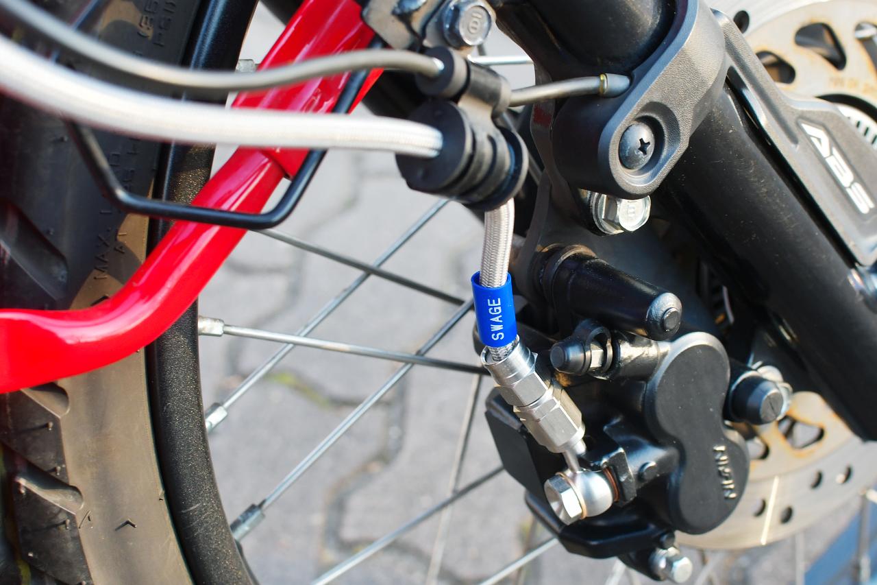画像: ステンメッシュホースといえばSWAGE-LINE（スウェッジライン）。ハンターカブのブレーキタッチを改善しつつ、ハイクオリティなスタイルを実現するぞ。 - webオートバイ