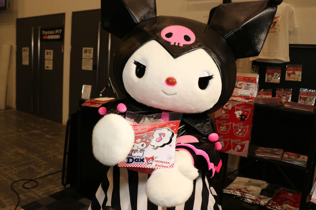 画像: コラボステッカーを紹介してくれるクロミちゃん。ダックスとのショットがお気に入りなのかも？