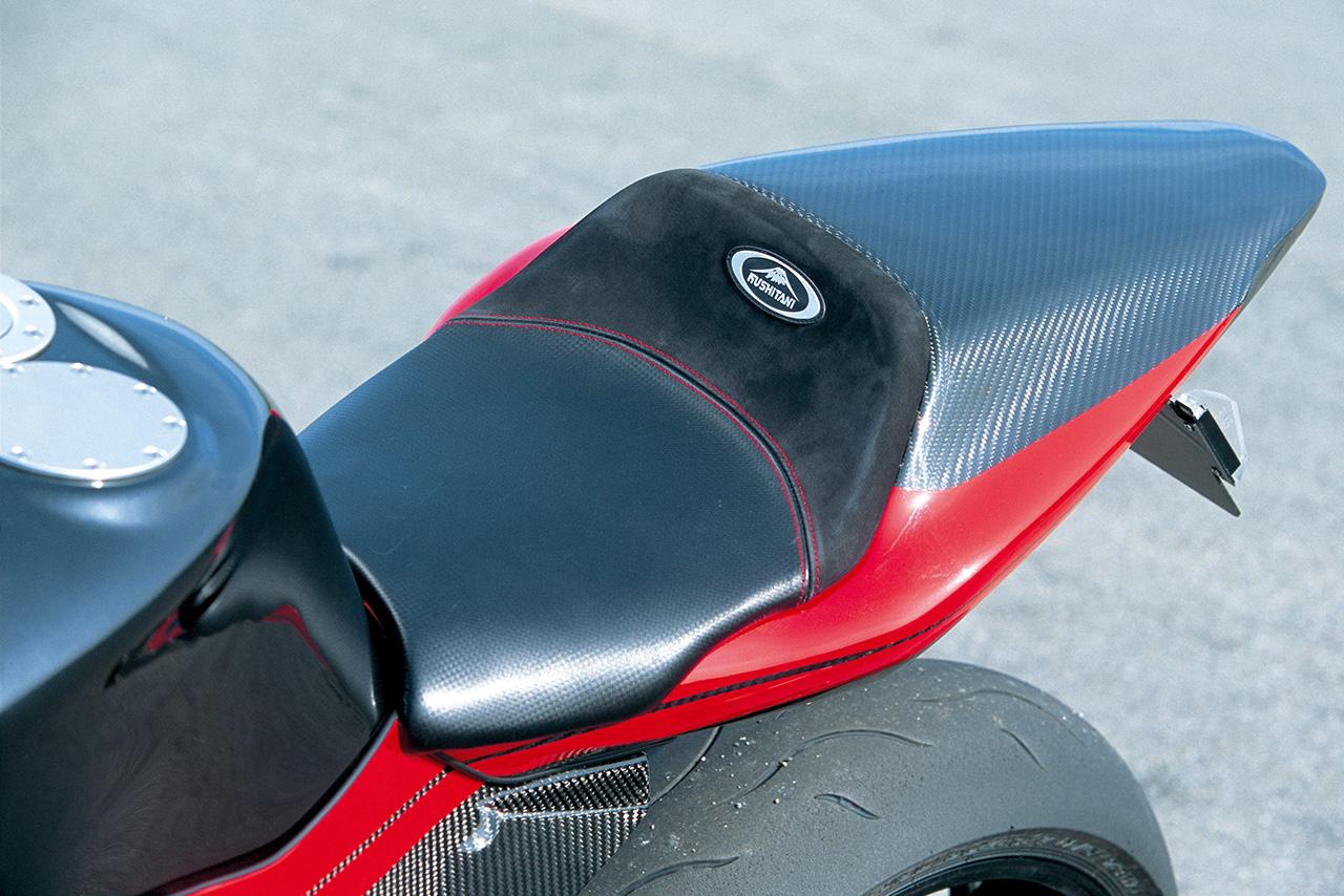 画像: スッキリとしたシートカウルをはじめ、各部の外装はドライカーボン製で軽量な仕上がりに。シートはクシタニと共同開発したレザーシートを採用し、テールランプとウインカーはともにLEDとなっている。