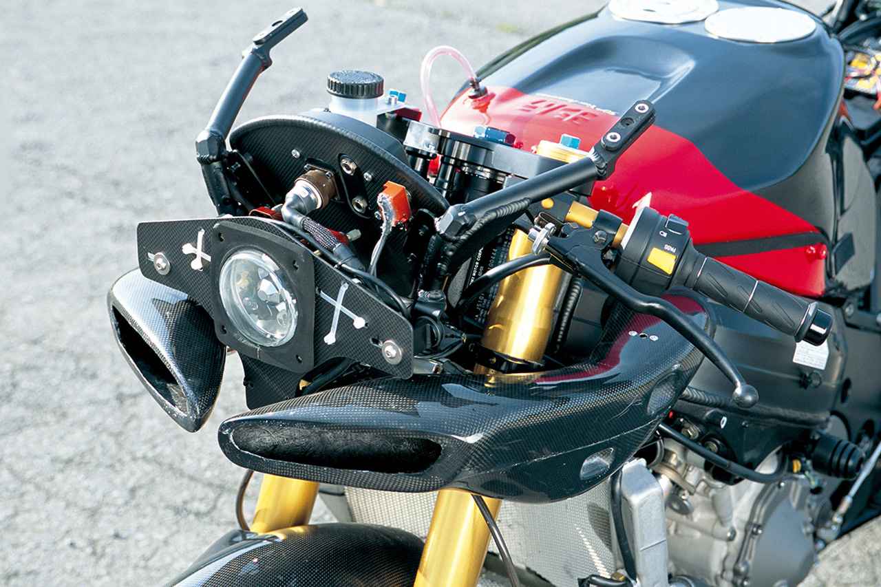 画像: カウルを外すと、カーボンのラムエアダクトが現れる。ヘッドライトや後述するメーターなどは、アルミステーで支持されている。外装パーツを外した際の姿は、レーシングマシンそのものといった感じとなっていた。