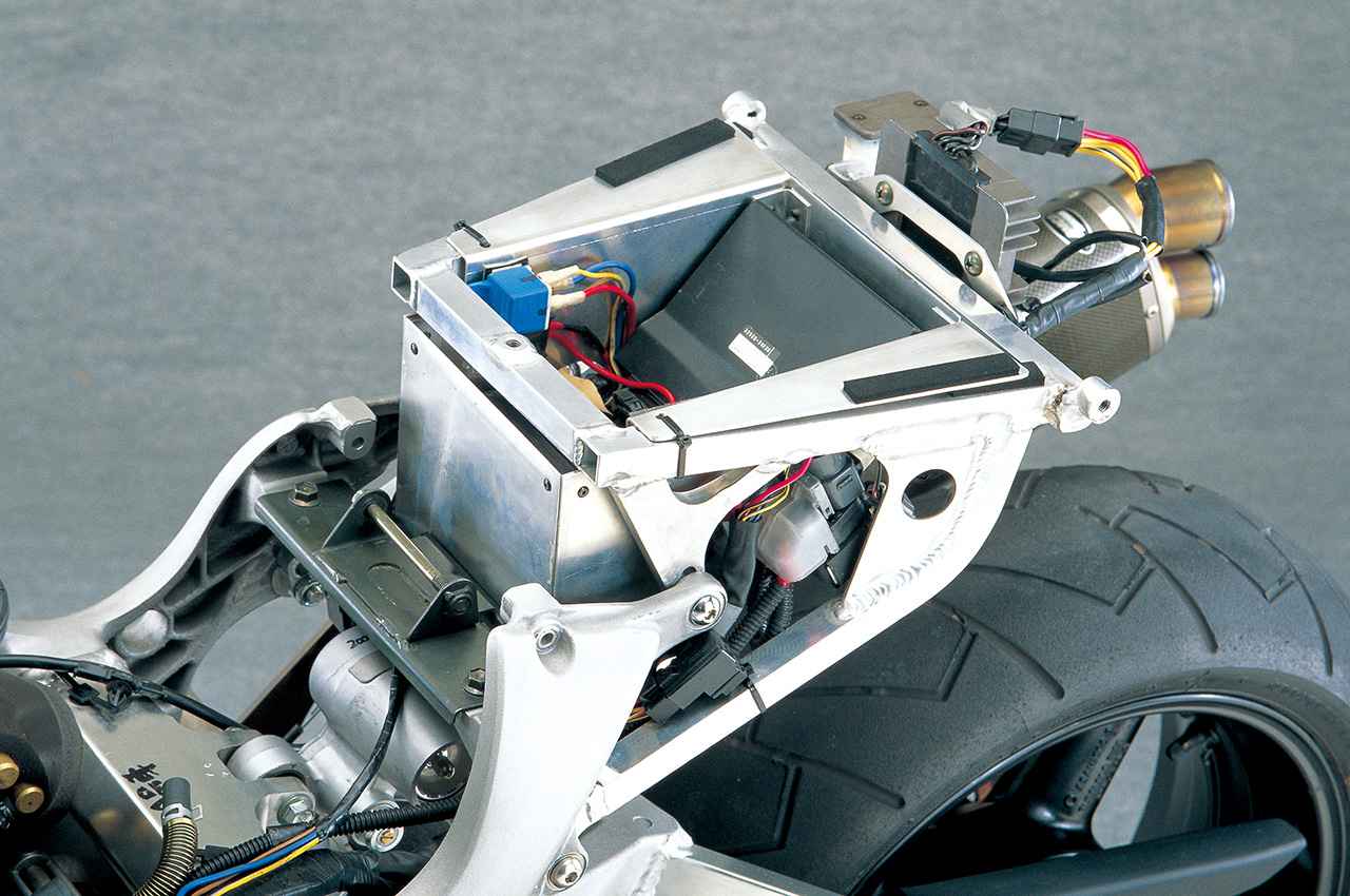 画像: 小型のアルミ製シートレールは、メインフレームとをつなぐ片側に2本あるボルトのうち、上側を差し替えることでシート高（実測では825mm）を15mm下げられる。バッテリーや電装を受けるカバーは、量産型ではFRP製となった。