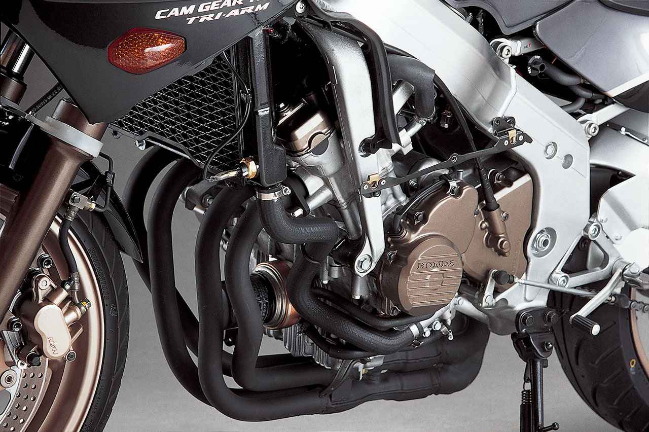 画像: CBR400Rが元の399.1cc(Φ55×42mm)水冷DOHC4バルブ並列4気筒は、ロッカーアームを廃してバルブ直押し式にするなどシリンダーヘッドを変更。吸排気バルブはステム径をΦ3.8mmと細くしながらIN/EX:Φ22/Φ19.5mmと傘径を大きくし、摺動抵抗を減らしつつ吸気効率を高めている。