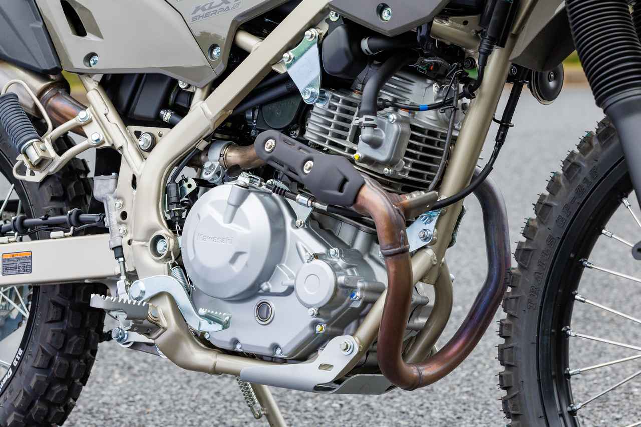 画像: 232ccの空冷OHCシングルは18PSを発揮。独特なエキパイの取り回しで管長を確保し、粘り強いトルク特性を実現する。