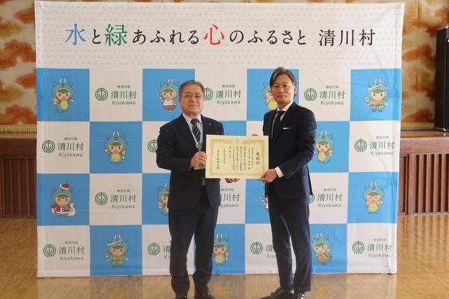 画像: ▲12月1日に行われた感謝状贈呈式の様子。神奈川県清川村 村長 岩澤吉美氏（左）と株式会社バイク王＆カンパニー 代表取締役CEO 澤篤史氏（右）の間で、清川村とバイク王の固い絆が確認されました。