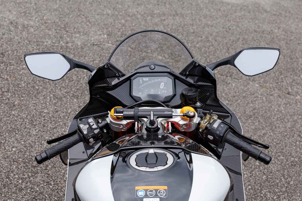 画像: ZX-10RR譲りのコクピットではあるものの、インナーパネルは全てカーボン製。ステアリングダンパーはオーリンズ製の電子制御。左側のスイッチにはクルーズコントロールも装備する。