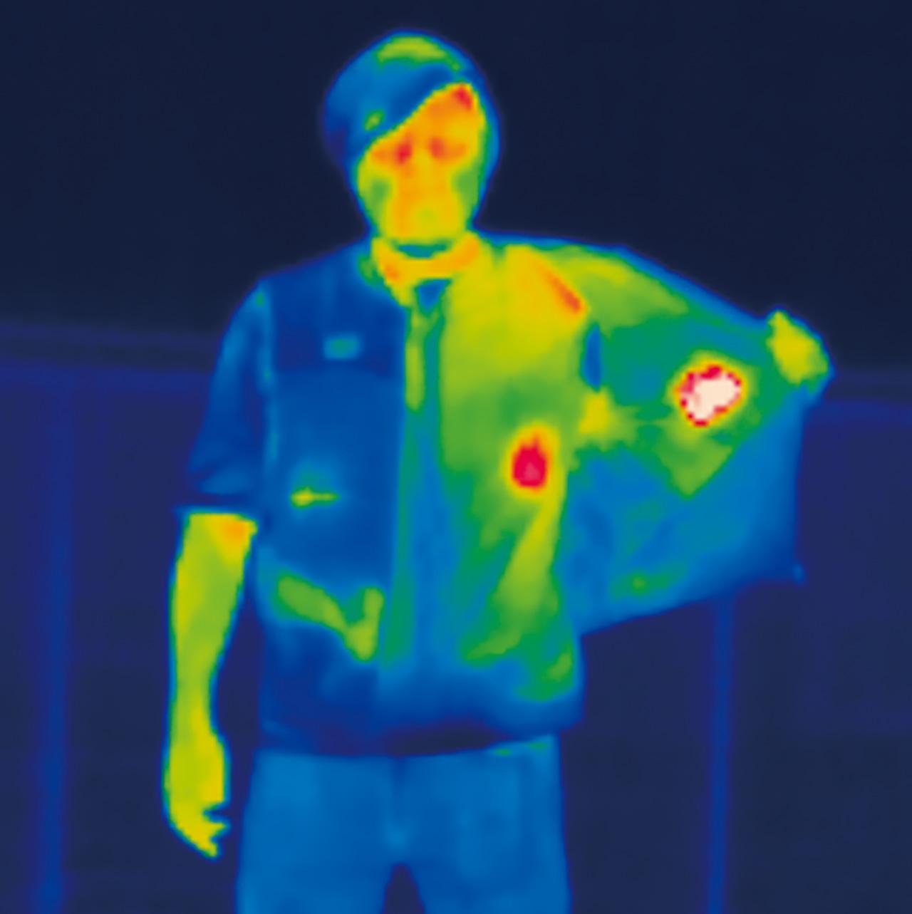 画像2: ▲ベストを着用しサーモカメラで見てみると、胸のヒーターが僅かに見える。次に半分脱いでみると、ヒーター部はもちろん、ベストに触れていた上半身全体の温度が上がっている。つまりアウターではなくインナーとして着用しないと電熱効果はない。