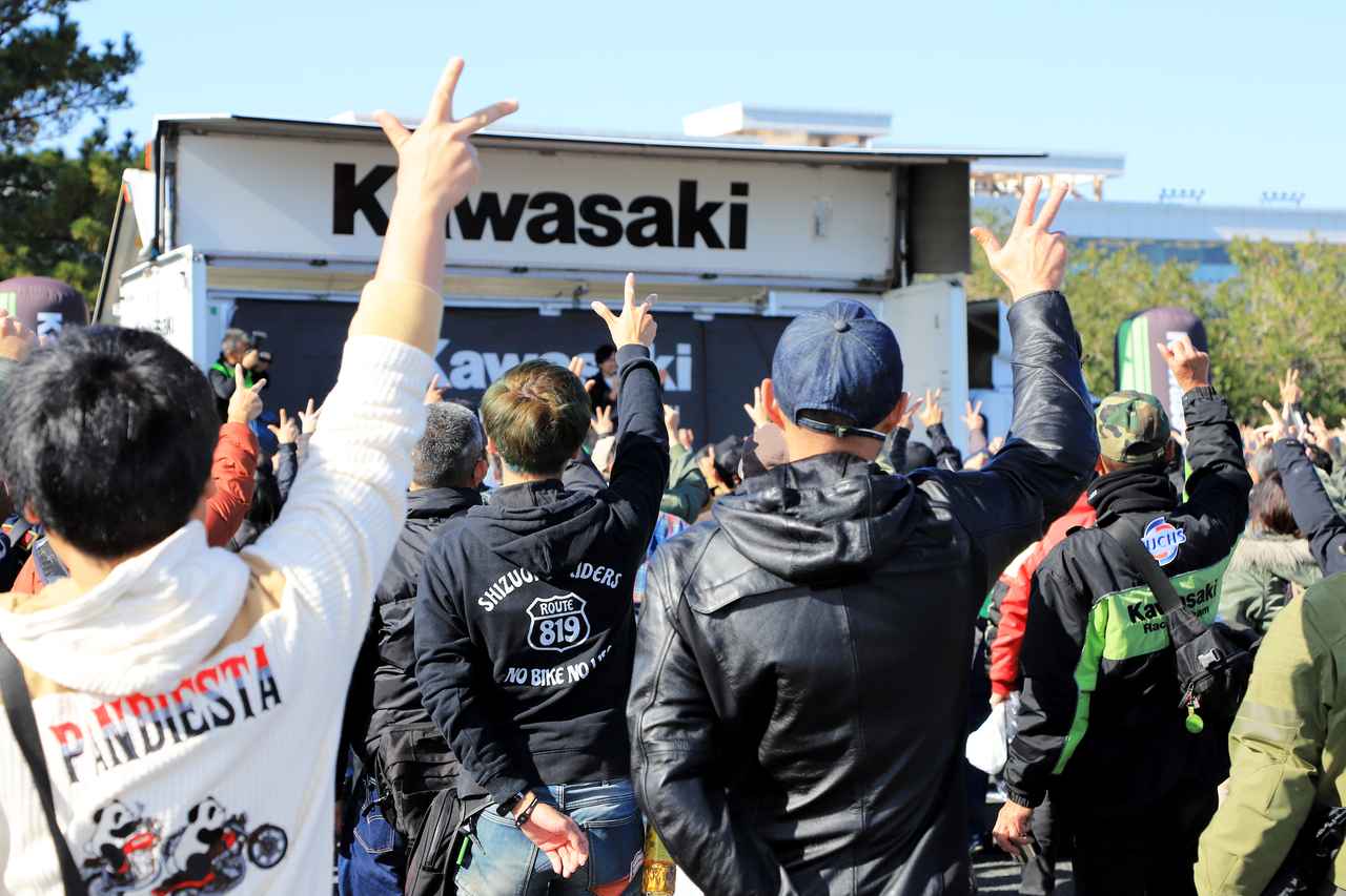 画像1: ▲「最初はK」から始まるのが、KCBMのじゃんけん大会では恒例となっています。MCは常連の参加者にはお馴染みとなっている塩田康介さんが今回も担当しました。賞品はハンチング帽やTシャツなど、モーターサイクルでも持ち帰りやすいアイテムばかりです。