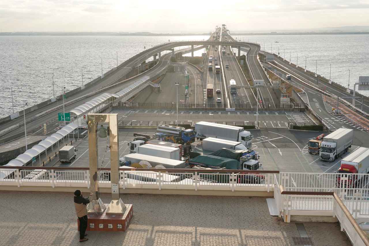 画像: ▲12月下旬の7時過ぎ、気温は約7℃。海ほたるPAでひとり「幸せの鐘」を鳴らす。この時間、東京湾アクアラインは下り線の方が混雑しているようだ。