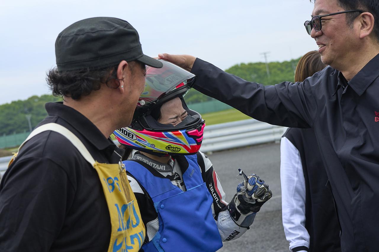画像: パドックに戻ると悔しくて涙が止まらない中山さん。ロイヤルエンフィールドの輸入元であるPCIの高永さんが讃える。