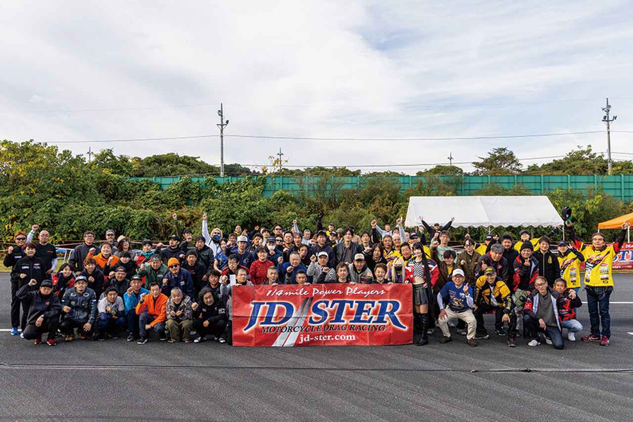 画像: ▲JD-STERドラッグレース、2025年最終戦でのエントラント集合写真。国内ではまだドラッグレースの認知が低いゆえ、パドックでの情報交換はそれぞれのスキルアップ、マシン・セッティングの方向づけにも大きな武器になる。自然とそんなエントラント同士の結びつきが強くなるのも、このモータースポーツの特徴なのだ。