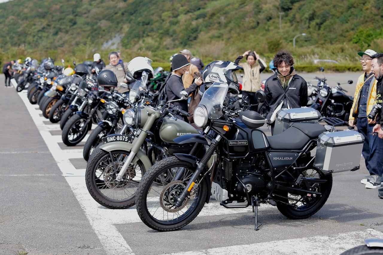 画像: 駐車場では車両を囲んでオーナー同士の交流が見られました。ゲストのドランクドラゴン鈴木さんもオーナーとの親睦を深めていました。