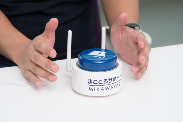 画像: MAGOボタンのMAGOは「まご」ころであり「孫」でもある。高度なテクノロジーを内包しながらも、「ボタンは1つ、電源はコンセントから」というアナログなデザインを徹底し、お年寄りの暮らしになじむデバイスにした。