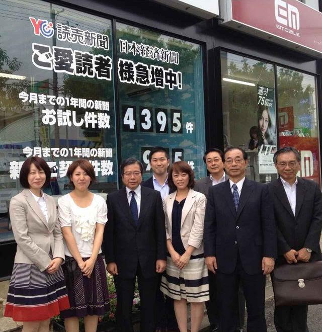 画像: 経営していた新聞販売店の前で撮影した写真。中央後ろが青木氏。