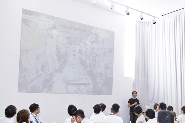 画像: 現在の宇宙船内部の様子を例に挙げ、アイデアのコンセプト検討の肝を語る西村氏。