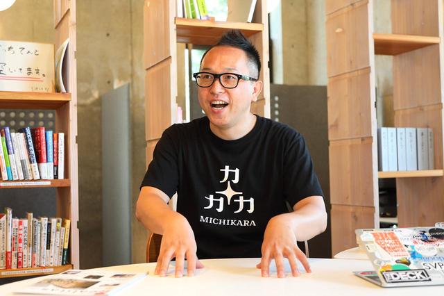画像: 山田氏が着ているのは、MICHIKARAのロゴ入りTシャツ。「市民・企業・市役所の3つの力が価値観や立場の違いを乗り越えて協力する」「“未知から”新しい価値を生み出す」「“この道から”新しい地域・未来をつくる」の3つの意味がMICHIKARAには込められている。