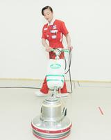 画像: 清掃をしている新津氏 ポリッシャーで床を磨く新津氏。数十キログラムあるポリッシャーを4階まで階段で運ぶこともあるという