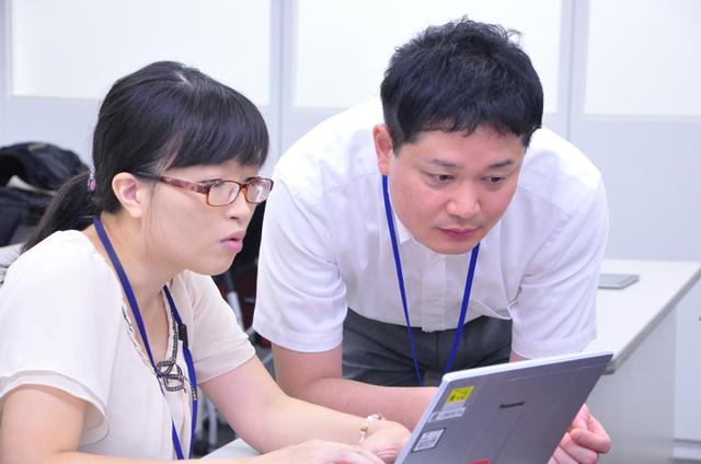 画像: お仕事かんたん生成。笑顔が消え、互いに協力しつつPepperに動きと言葉を仕込む。