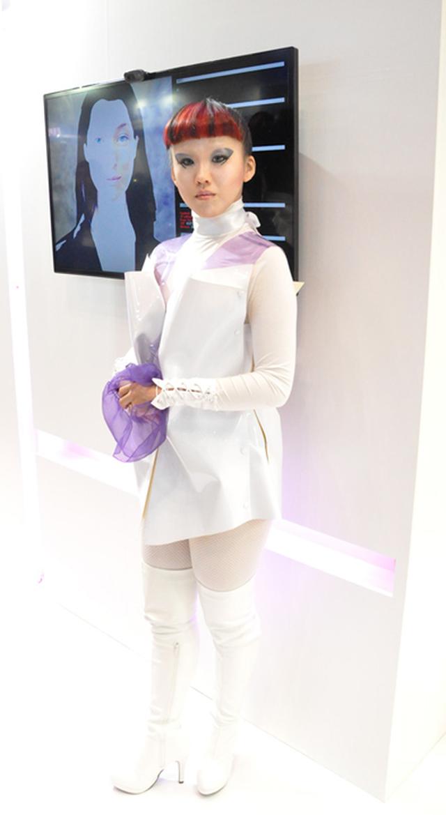 画像: もしかしてロボット?と思い、恐る恐る「写真とっていいですか?」と聞くとにっこりOKしてくれたコンパニオンの方。当社ブースのご近所さんの日本ルナウエアAIテクノロジーズ社での写真。ゲームなどに特化した専用型AIではなく汎用型のAI(New Yorkのエンジニアが開発)を展示されてます。例えば、人気講師のパーソナリティーまでをも模倣して、複数の教育機関でAIが講師を務めるなどの応用も視野に入れているとのこと。ディスプレーに表示されるAIの顔でしゃべるのではなく、将来的には実物のロボットに搭載することも考えていて、今回のコンパニオンの姿は、そのときのイメージを表現しているとのこと