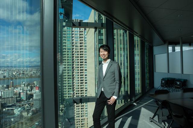 画像: 梅田のとても見晴らしのよいフロアにオフィスを構えています。撮影は昨年の11月。陽が大分低くなっていて、色合いに出ていますね。彼はエンジニアです。普段は愛妻弁当派とのこと。しかし撮影は昼食の後。阿部さんの本領が発揮できませんでした。