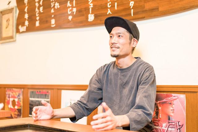 画像: 店主の藤元重臣さん。2階への階段の壁に飾ってあるのは趣味で集めたレコード。これがきっかけでお客さまと話が弾むことも。友人の家に遊びに来たような雰囲気の「ひめぜん」には、老若男女、国籍問わず、地元の方から観光客まで幅広いお客さまが訪れています。テレビや雑誌などで取り上げられる機会も多く、サイン色紙もずらり。