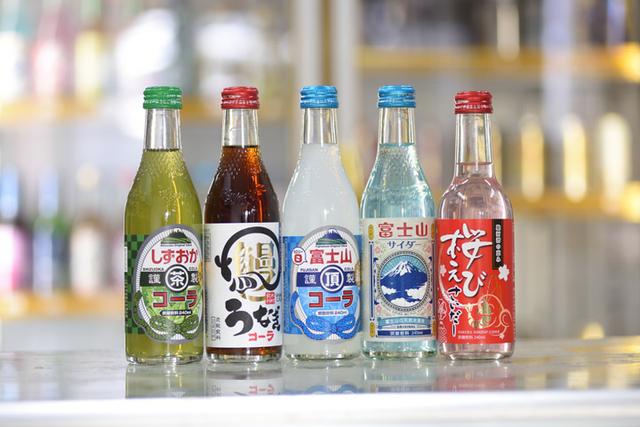 画像: ご当地商品。左から「しずおかコーラ」「うなぎコーラ」「富士山頂コーラ」「富士山サイダー」「桜えびサイダー」。どれも最近の人気商品です。