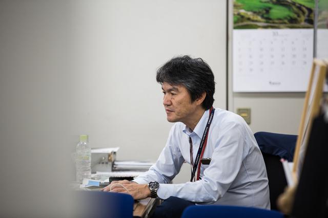画像: 出先から戻り、すぐに資料を確認中の支店長。