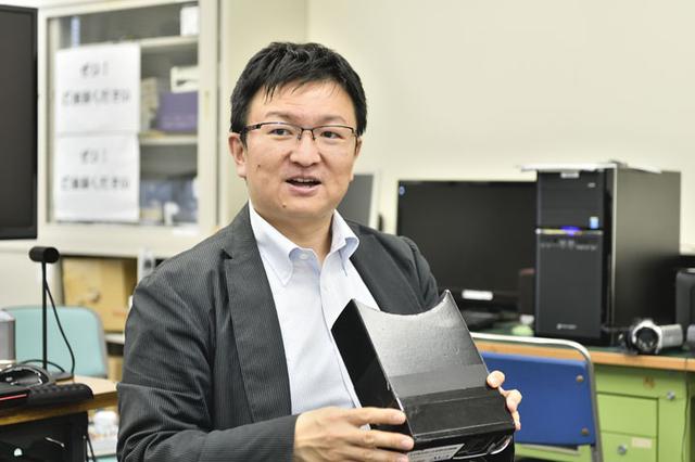 画像: 愛知工科大学 工学部情報メディア学科 教授 板宮 朋基 氏。手に持たれているのが、AR災害疑似体験アプリ「Disaster Scope(ディザスタースコープ)」