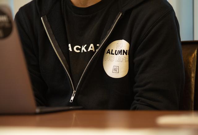 画像: 社名やロゴ、アルムナイマークが印刷されたTシャツとパーカーをさり気なく着こなし、おしゃれです。