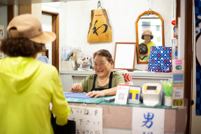 画像: 午後3時、のれんを出すのと同時に常連のお客さんたちがやってくる。受付に座る母のとよ子さん