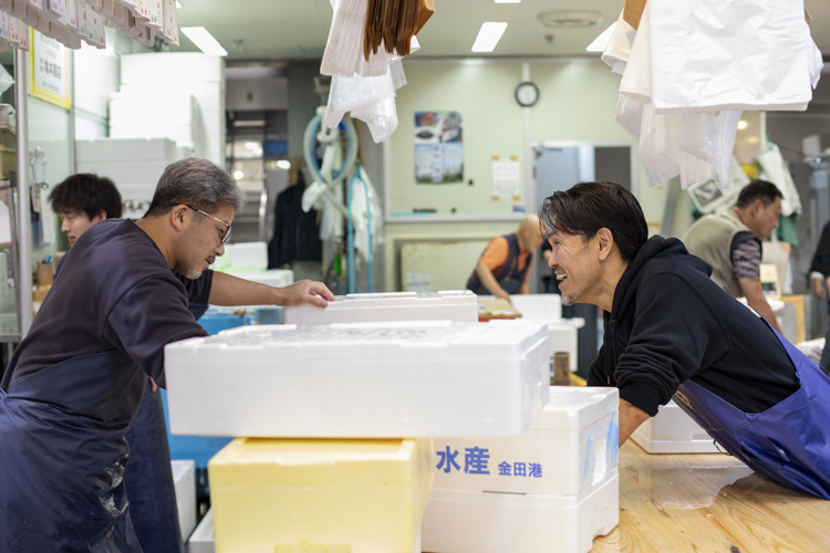画像: その日の配達、発送分を得意先ごとに箱詰めし終えて、ひと息つく原田さんとスタッフの堀さん。店に来る客のために店頭に魚を陳列し始める