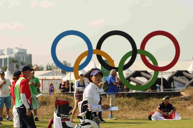 画像: 五輪マークの前でニコリ