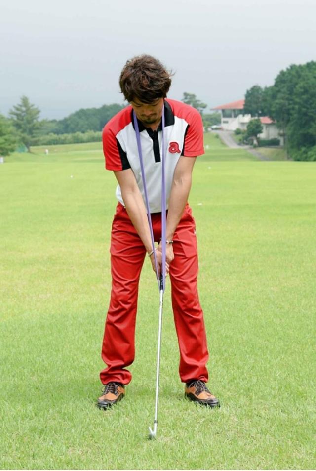 画像: 輪っか状にしたゴムバンドを首からかけ、クラブのグリップ部分に引っかけてアドレス